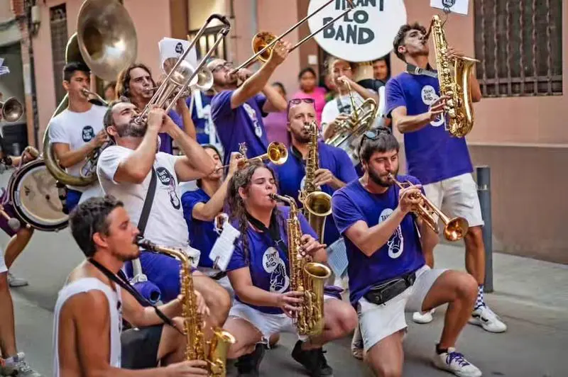 Músics de Tirant Lo Band agenollats tocant al carrer